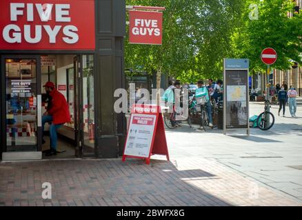 Alltag unter Coronavirus Covid-19 Pandemie Sperrung: Lieferung Radfahrer warten vor fünf Jungs Restaurant Stockfoto