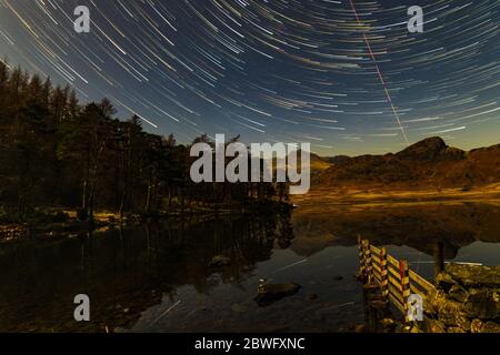 Sterne Trails über Blea Tarn in einer mondhellen Nacht Stockfoto