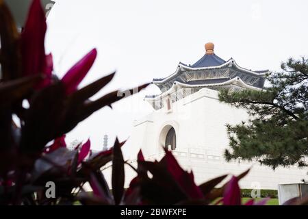 Atemberaubende Aussicht auf die National Chiang Kai-Shek Memorial Hall in der Ferne und verwackelte Pflanzen im Vordergrund. Taipeh, Taiwan. Stockfoto