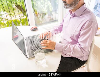 Mann, der mit dem Notebook arbeitet. Intelligentes Arbeiten. Stockfoto