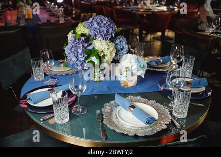 Wunderschön geserviertes Tischchen mit Geschirr und Blumen Stockfoto