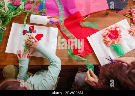 Blick von oben auf zwei Kinder, die Kunst und Kunsthandwerk machen Ein Holztisch Stockfoto