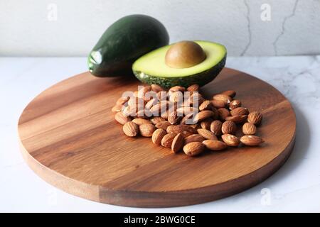 Draufsicht auf Mandel und Avocado auf dem Schneidebrett. Stockfoto