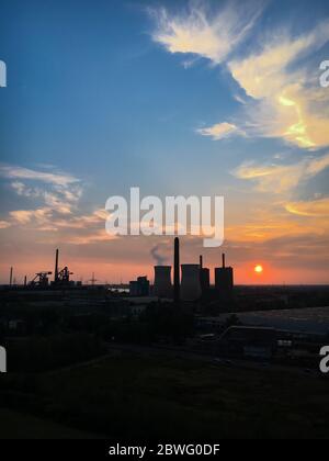 Duisburg – 28. August 2018: Blick auf Kraftwerk und Kühlturm der „RWE Power AG“ bei Sonnenuntergang vor buntem Himmel Stockfoto