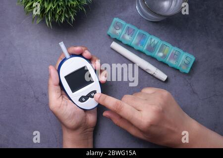 Frauen Hand Messung diabetischer Glukosespiegel zu Hause Stockfoto