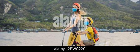 Aktive Schulkind und seine Mutter in medizinischen Maske und Schutzhelm Reiten ein Fahrrad mit Rucksack an sonnigen Tag. Fröhliches Kinderradeln auf dem Weg zur Schule. Sie Stockfoto
