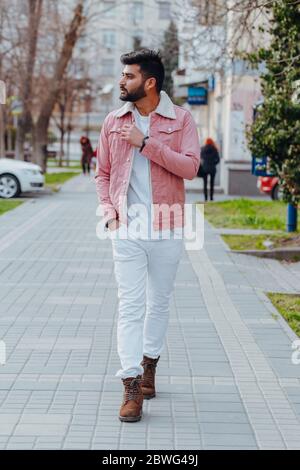 Stilvoll gekleideter indischer Bärtiger geht die Straße hinunter. Stockfoto