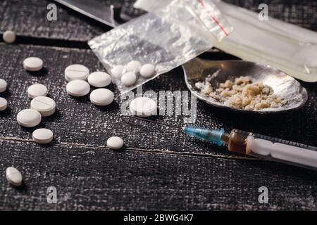 Harte Drogen auf dunklem Tisch. Spritze und gekochtes Heroin Stockfoto