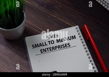 Book about SMEs - Small To Medium Enterprises isolated on wooden table. Stockfoto