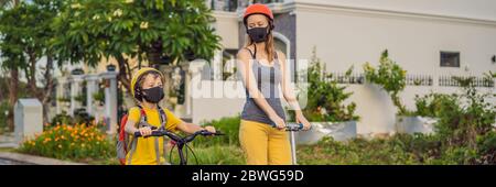 Aktive Schulkind und seine Mutter in medizinischen Maske und Schutzhelm Reiten ein Fahrrad mit Rucksack an sonnigen Tag. Fröhliches Kinderradeln auf dem Weg zur Schule. Sie Stockfoto