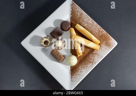 Detailansicht einer köstlichen Bonbons auf weißem Teller auf dunkelgrauem Tisch... Stockfoto