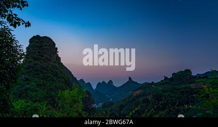 Xianggong Hügel Blick auf schöne grüne, üppige und dichte Karstgebirgslandschaft in der Dämmerung, Yangshuo, Guangxi Provinz, China Stockfoto