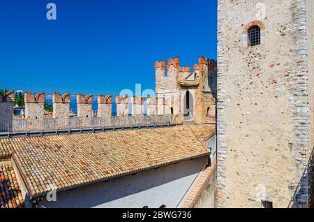 Sirmione, Italien, 11. September 2019: Steinmauer mit Ziegel und Ziegel Turmgebäude von Scaligero Burg Castello mittelalterliche Festung, Stadt am Gardasee, blauer Himmel Hintergrund, Lombardei Stockfoto