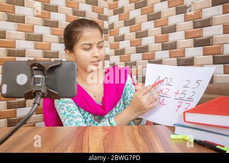 Mädchen, die online virtuellen Kurs auf dem Handy, beschäftigt in Unterricht zu Hause während covid-19 oder Coronavirus Pandemie Krise - Konzept der E-Unterricht Stockfoto