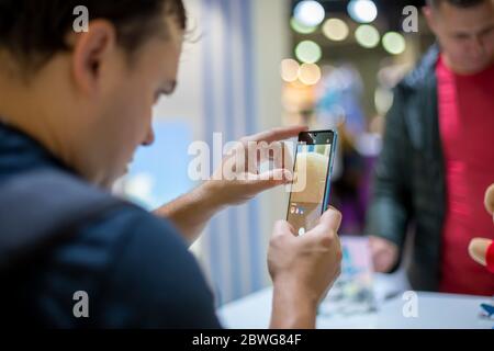 Moskau, Russland - 04. Oktober 2019: Moskau, Russland - 04. Oktober 2019: Ein kaukasischer Mann hält neues Flaggschiff-Smartphone huawei p30 pro und trst Kamera Stockfoto