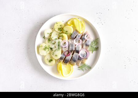 In Scheiben geschnittener Heringsfisch mit gekochten Kartoffeln. Russische Küche. Draufsicht, flaches Lay Stockfoto