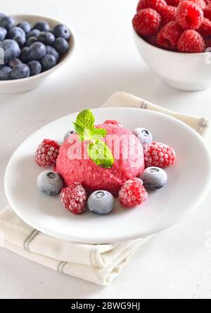 Himbeer-Sorbet auf Platte auf Steinhintergrund. Kaltes Dessert im Sommer. Stockfoto