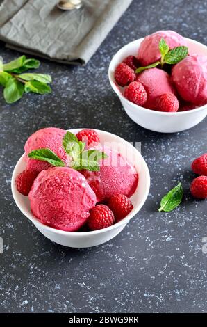 Himbeer-Eis in Schüssel auf Steinhintergrund, Nahaufnahme Stockfoto