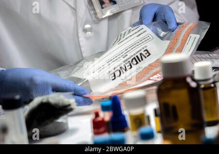 Polizei spezialisiert Entnahme Probe einer Tasche von Beweismitteln in forensischen Labor, konzeptionelles Bild Stockfoto