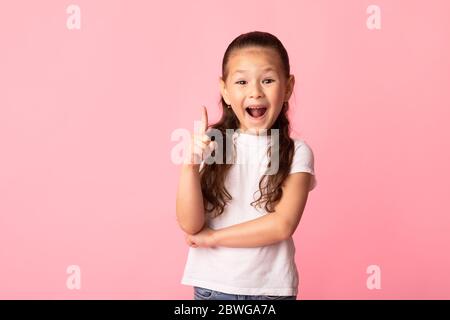 Aufgeregt asiatische Mädchen hat tolle Idee und Punkte nach oben Stockfoto