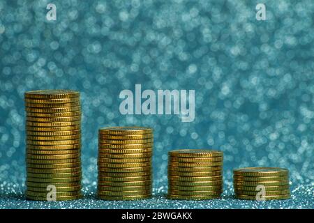 Pyramide von Stapeln von Goldmünzen auf einem blauen Hintergrund. Stockfoto