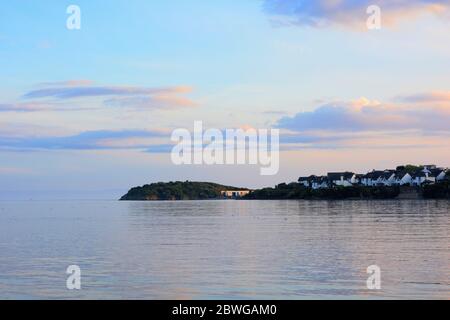 Barry, Wales, der Damm und Punkt auf Barry Island am Horizont. Flut mit Sonnenuntergang und Wolken über dem Himmel verstreut. Stockfoto