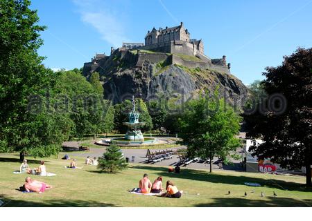 Edinburgh, Schottland, Großbritannien. Juni 2020. Menschen, die soziale Distanz praktizieren, während sie sich entspannen und in den West Princes Street Gardens sonnen, zu Beginn der ersten vollen Woche der Lockdown-Maßnahmen in Schottland aufgrund der Coronavirus-Pandemie, mit Blick auf Edinburgh Castle. Kredit: Craig Brown / Alamy Live News Stockfoto