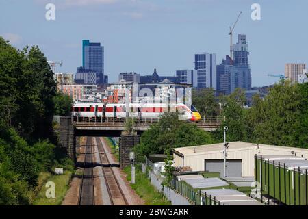 Ein von LNER betriebener Zug der Baureihe 800 Azum fährt vor der Skyline von Leeds in die Innenstadt von Leeds Stockfoto