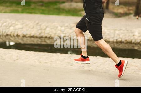 Sportler, der im Park läuft, Seitenansicht der Beine Stockfoto