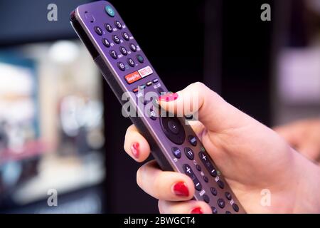 Moskau, Russland - 04. Oktober 2019: Moskau, Russland - 04. Oktober 2019: Moskau, Russland - 04. Oktober 2019: Weibliche Hand hält eine Smart-TV-Fernbedienung mit einem Stockfoto