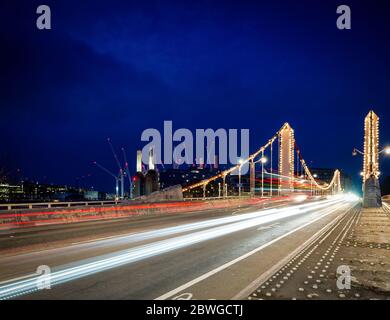 Lichtpfade und Verkehr über die Albert Bridge, die Themse London bei Nacht mit Kraftwerk Battersea im Hintergrund Stockfoto