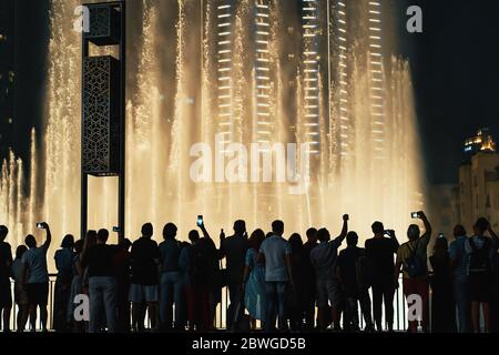 DUBAI, VAE - Februar 2020 : Nachtansicht von Dubai Dancing Fountains Downtown und viele Menschen, die sich die Wassershow ansehen. Stockfoto