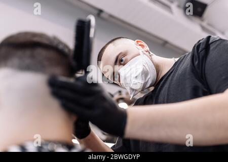 Haarschnitt in Quarantäne. Haarschnitt in Masken aus dem Virus. Haare und Gesundheit zu pflegen. Stockfoto