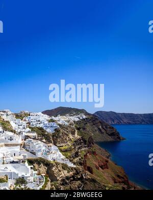 Insel Santorini, Kykladen, Griechenland. Panoramablick auf Caldera über Ägäis Hintergrund, blauer Himmel. Traditionelle weiß getünchte Häuser mit blauem Roo Stockfoto