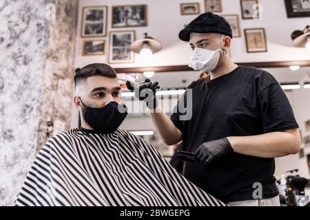 Haarschnitt in Quarantäne. Haarschnitt in Masken aus dem Virus. Haare und Gesundheit zu pflegen. Stockfoto