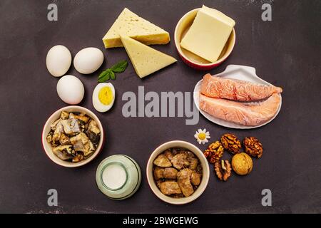 Lebensmittel mit Vitamin D. Käse, Eier, Butter, Nüsse, Milch, Sardine. Schwarzer Kreidetafel Hintergrund Stockfoto