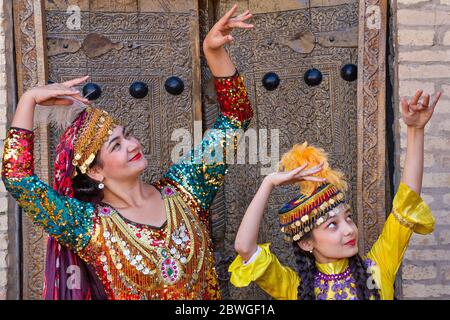 Usbekische Damen in lokaler Kleidung, die traditionelle Tänze in Chiwa, Usbekistan, vorführen Stockfoto