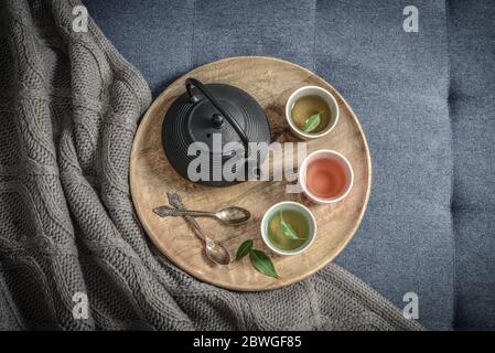 Schwarzes Eisen Asian Tee-Set auf Holztablett auf gestrickten Plaid, Draufsicht Stockfoto