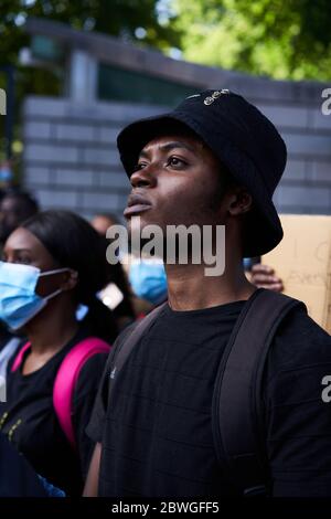 Porträt eines jungen schwarzen Mannes, der vor der US-Botschaft in Dublin protestiert. Stockfoto