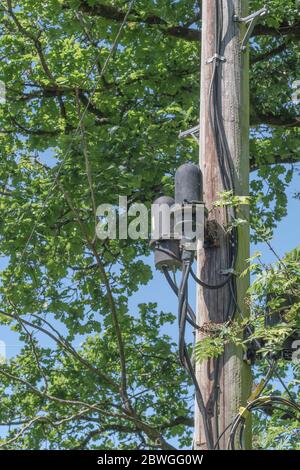 Rural BT Versorgungsmast mit verschiedenen Glasfaser-Breitbandinstallationen. Metapher ländliche Breitbanddienste, ländliche Konnektivität, kabelgebundene ländliche Umgebung. Stockfoto