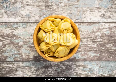 Tortellini Pasta. Italienische gefüllte Pasta in Holzschale. Draufsicht. Stockfoto