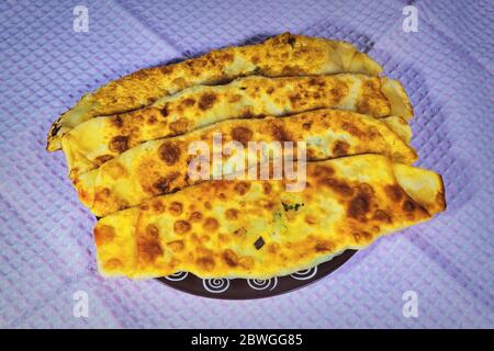 Frisch gebackene hausgemachte Tortillas mit grünen Zwiebeln und Spargel auf einem Teller Nahaufnahme. Stockfoto