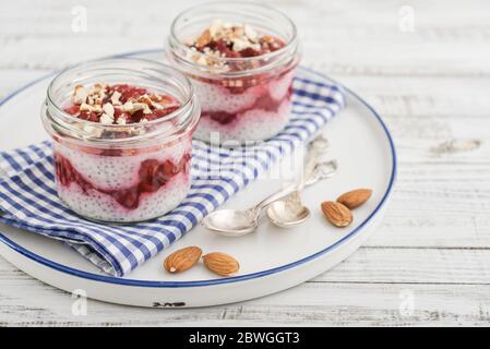 Chia Pudding mit Kirsche und Mandel in Gläsern auf Tablett Stockfoto