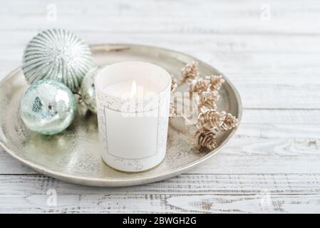 Tablett mit weihnachtsschmuck und Kerze auf weißem Holzhintergrund Stockfoto