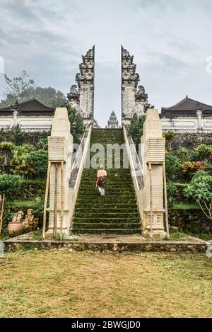 Frau auf der Treppe zum Eingang des Pura Lempuyang Tempels auf Bali, Indonesien Stockfoto