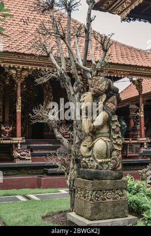 BALI, INDONESIEN - 12. JANUAR 2018: Traditionelles balinesisches Haus mit lächelnder Skulptur auf Bali, Indonesien Stockfoto