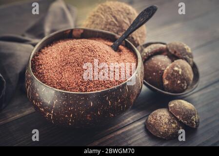 Kokosnuss Palme granulierter Zucker in einer Schüssel mit jaggery Kokosnuss auf Holzhintergrund Nahaufnahme Stockfoto