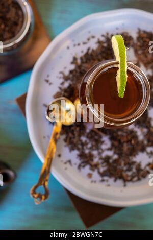 Schwarzer Tee auf Vintage-Hintergrund, für einen heißen Tag, Bio mit Flasche Stockfoto