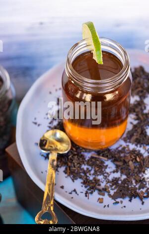 Schwarzer Tee auf Vintage-Hintergrund, für einen heißen Tag, Bio mit Flasche Stockfoto