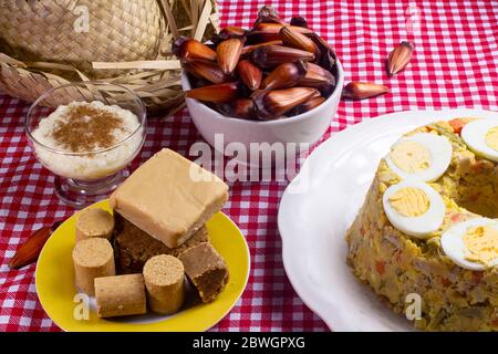 Typisch brasilianische Junina Party Food und Süßigkeiten. Couscouz, Erdnussbonbons, süßer Reis, Dulces de leche und Pinienkerne. Stockfoto